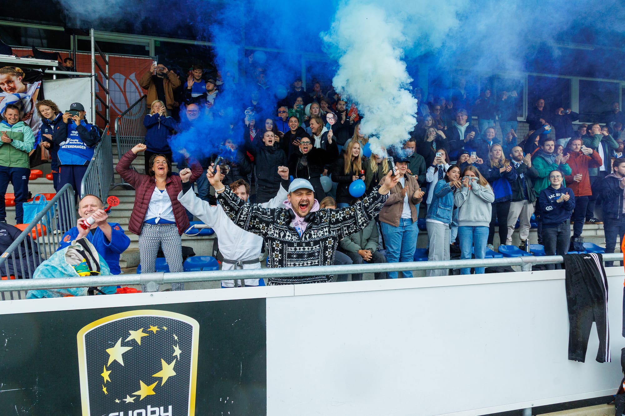 AAC supporters celebrate in the stand with blue smoke at the women’s Ereklasse final